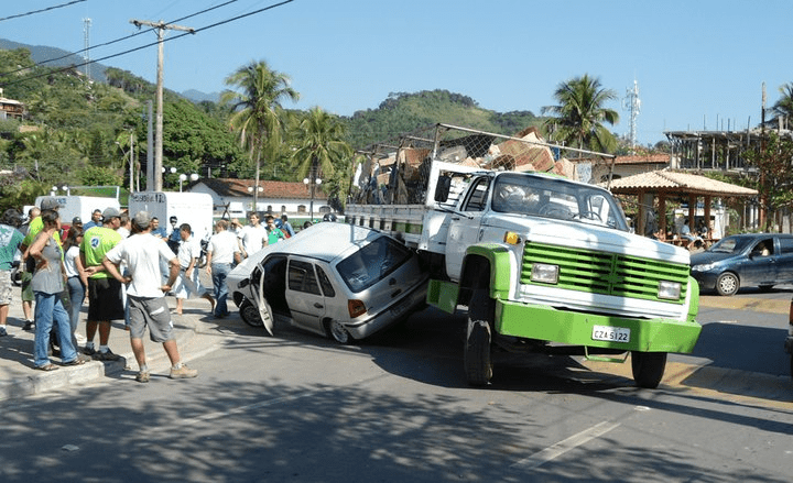 Imagem de um caminhão da prefeitura envolvido em acidente registrado por Gilda Pinna, onde funcionários ficam pendurados na parte traseira para coleta de resíduos recicláveis